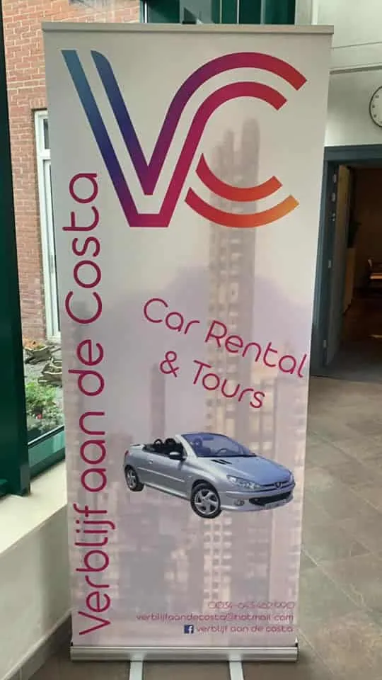 Roll-up banner met groot kleurverloop-logo, skyline en cabrio