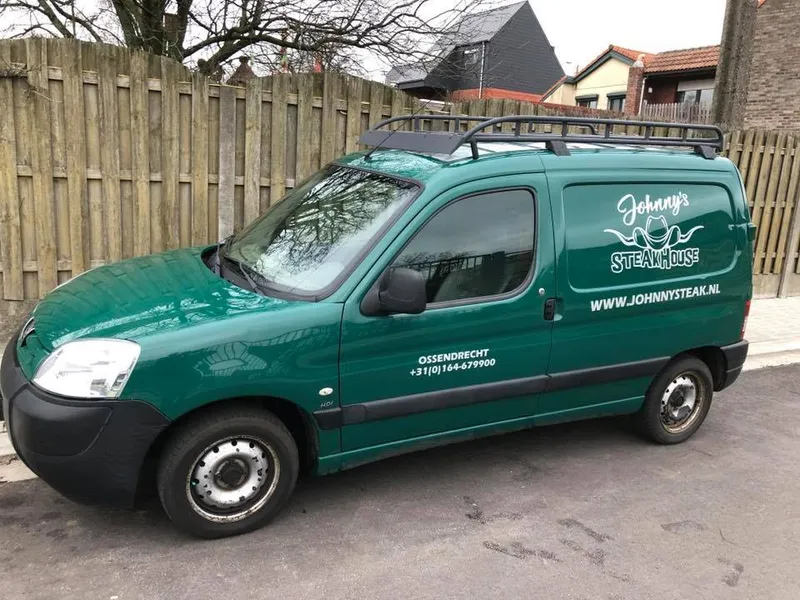 Groene bestelwagen met wit logo, website en telefoonnummer