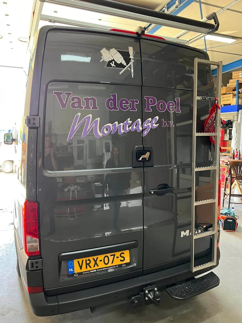 Grijze bestelbus van achteren met logo en paarse belettering op de achterdeuren
