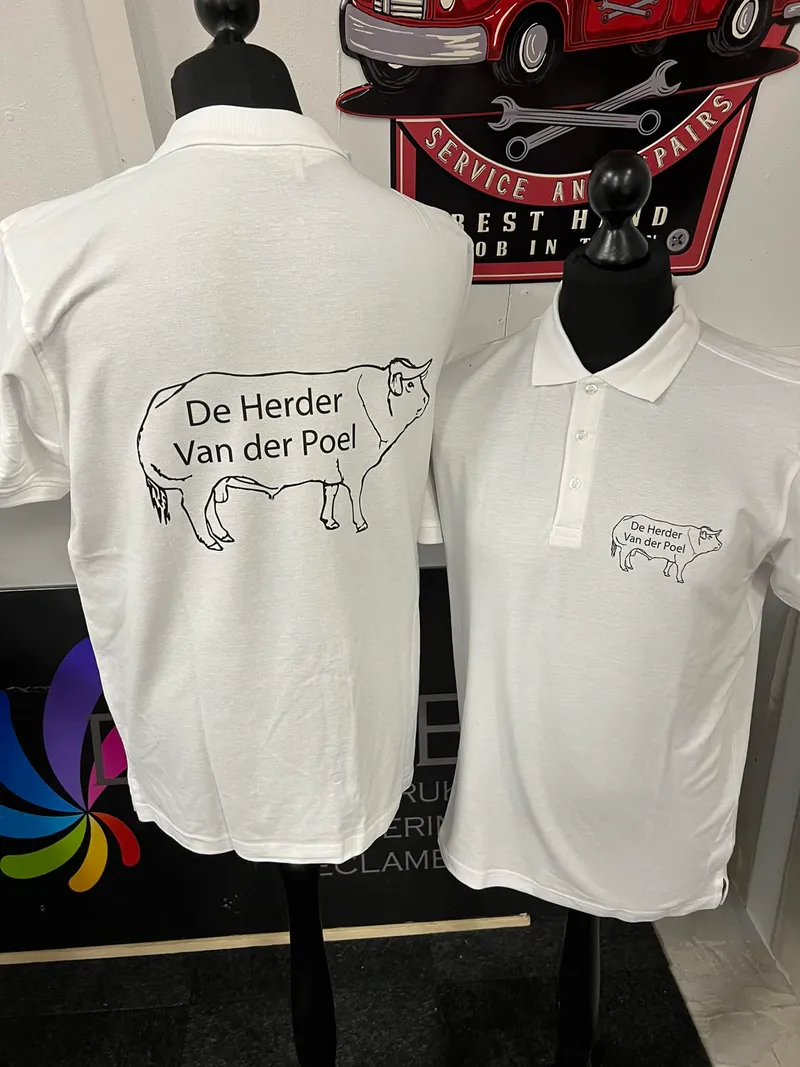 Twee witte polo's op paspoppen met zwarte lijntekening van een stier en tekst