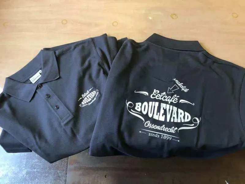 Twee donkere polo's met wit logo op borst en groot logo op de rug