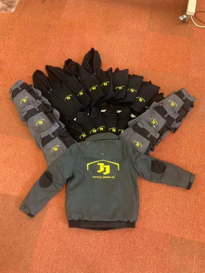 Waaier van hoodies, polo's, werkbroeken en een jas met geel logo