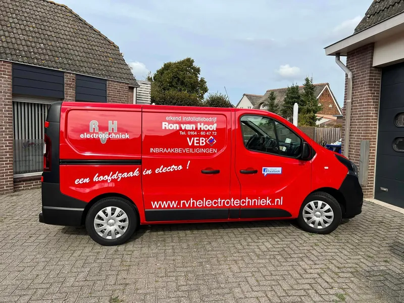 Rode bestelbus van opzij met logo, slogan, keurmerk en website