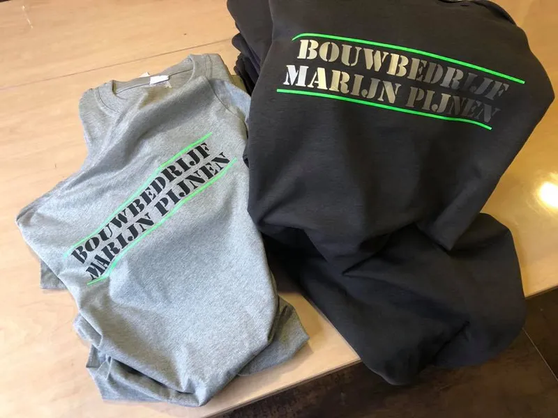 Grijze en zwarte T-shirts met stencil-opdruk en groene lijnen