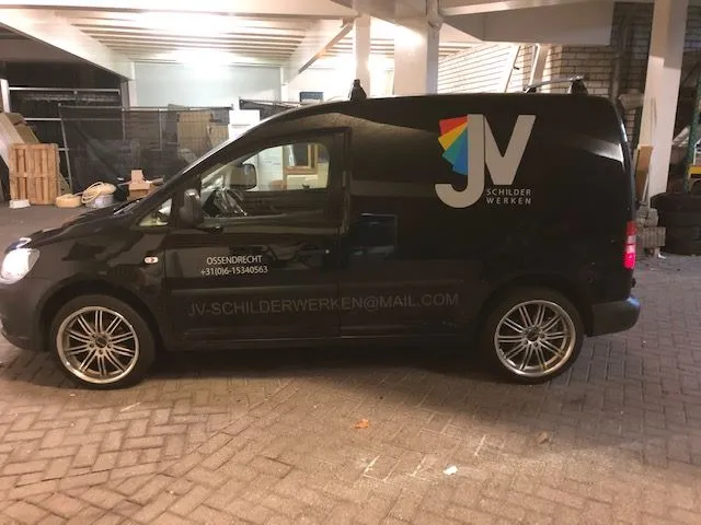 Zwarte bestelauto met kleurrijk logo en contactgegevens op de zijkant