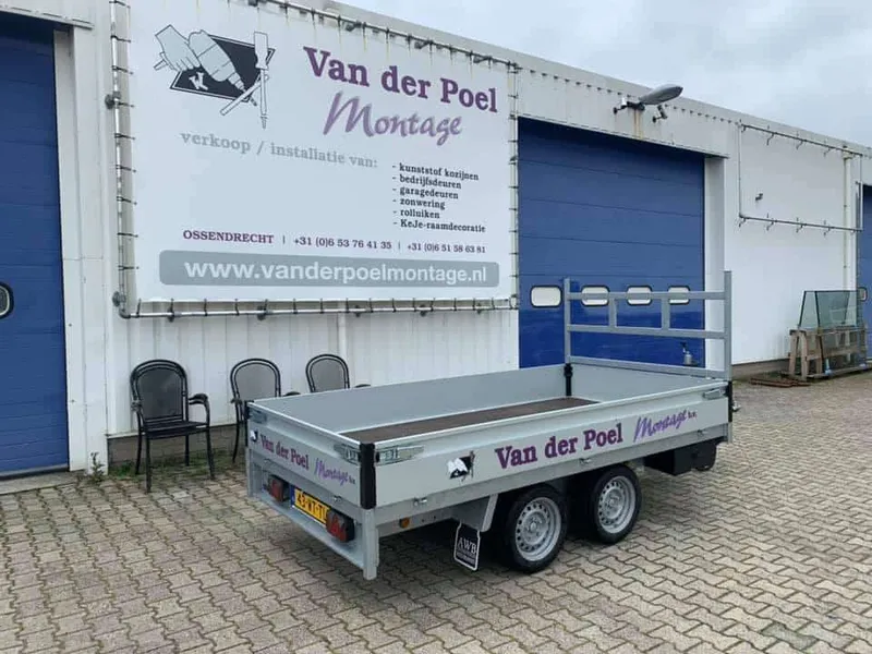 Open aanhanger met paarse belettering voor een bedrijfspand met groot spandoek