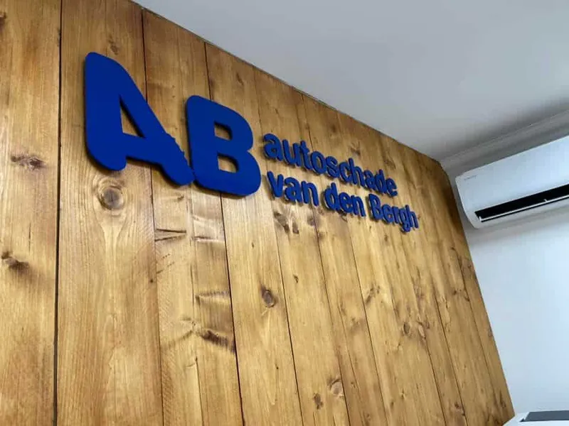 Blauwe 3D-letters met logo en bedrijfsnaam op een houten binnenwand