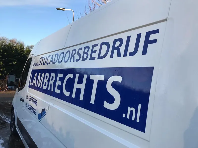 Close-up van witte bus met blauwe belettering en telefoonnummers