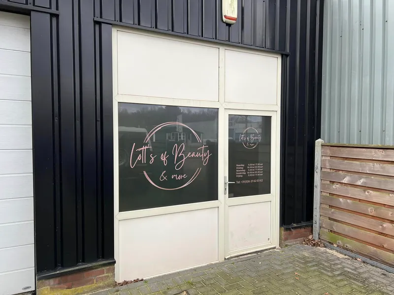 Bedrijfsdeur en raam met roségouden logo en openingstijden op donkere raamfolie