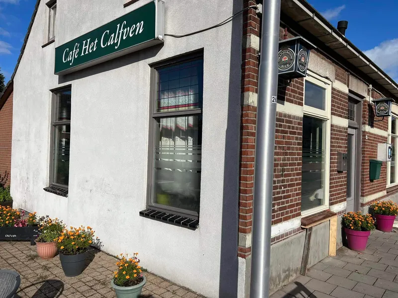 Hoekpand met groene lichtbak met naam en matglasfolie op de ramen